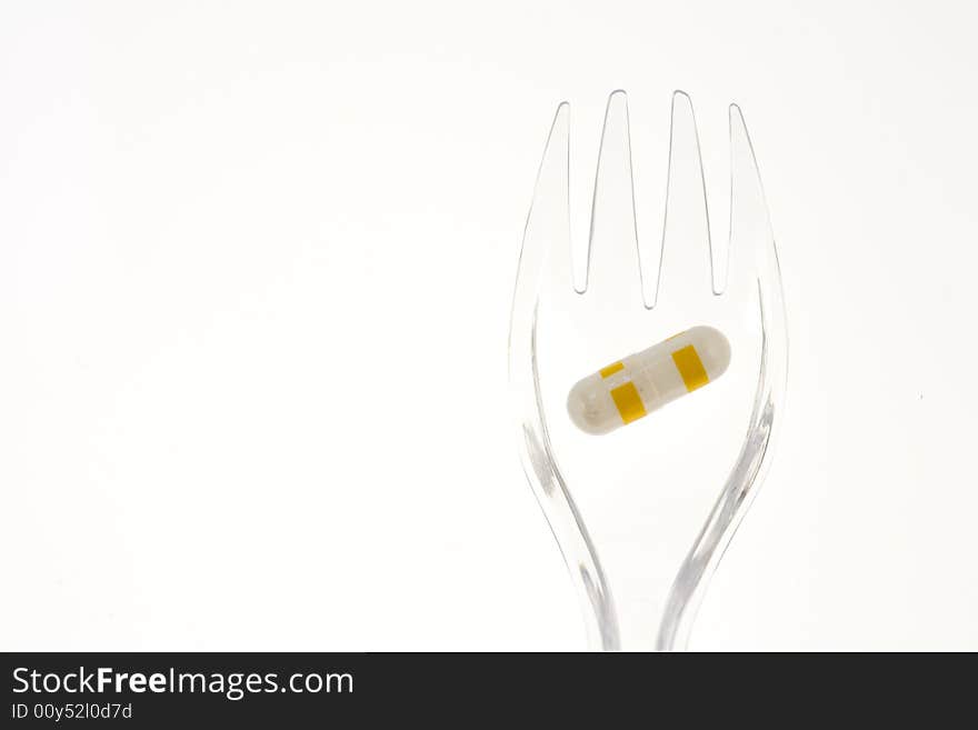 Fork with pills on a white background. Fork with pills on a white background