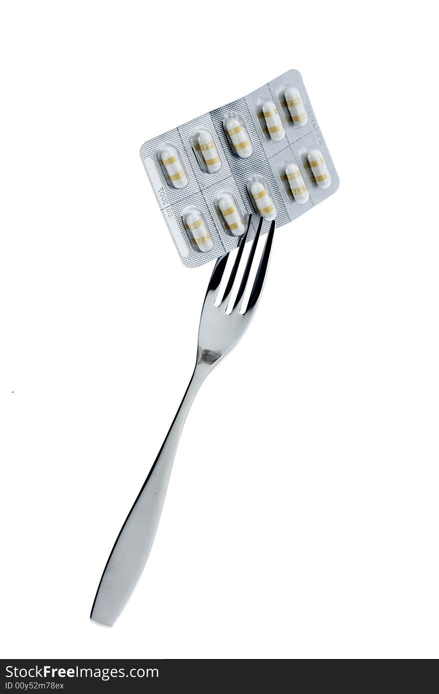 Fork with pills on a white background. Fork with pills on a white background