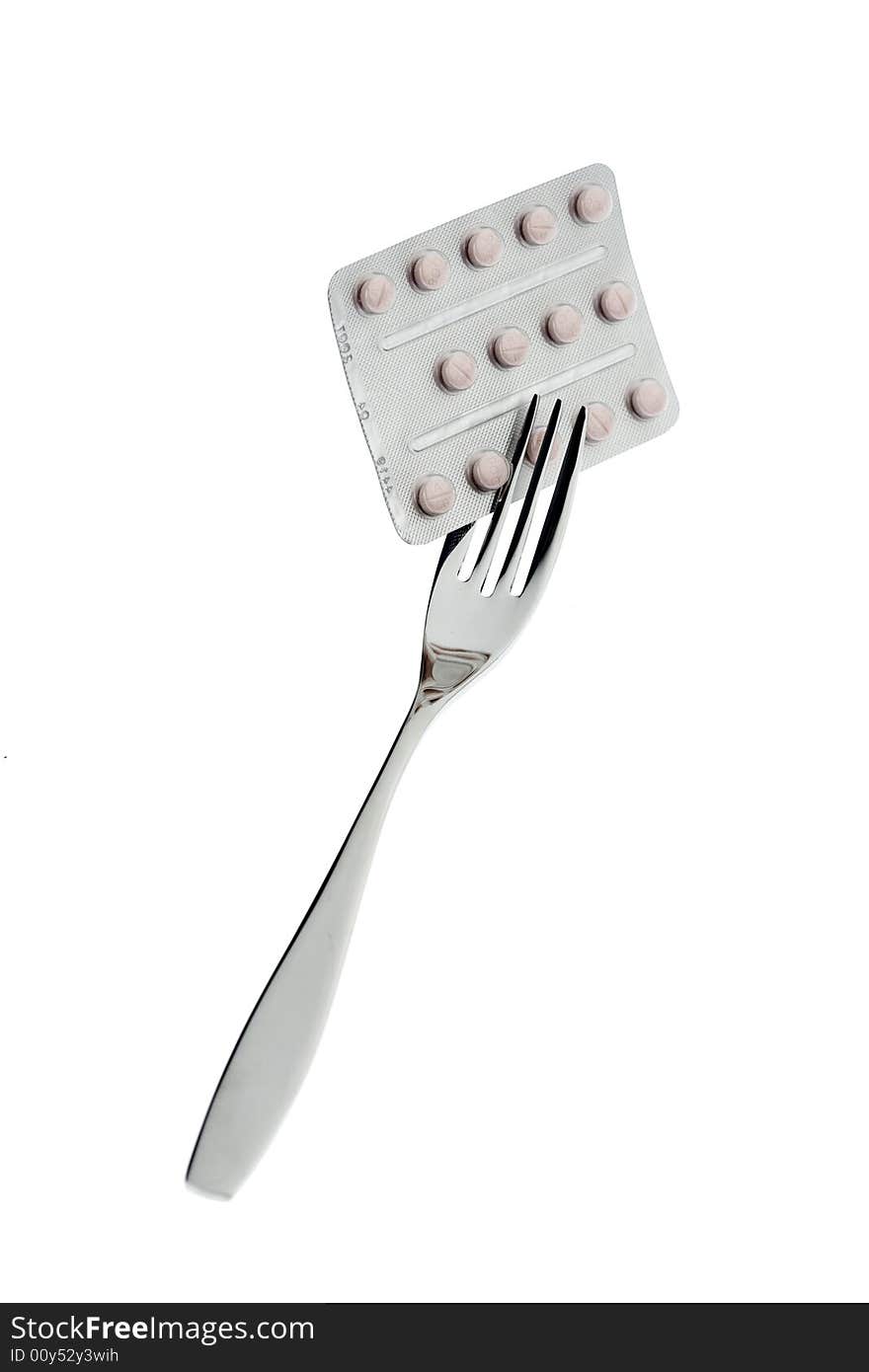 Fork with pills on a white background. Fork with pills on a white background