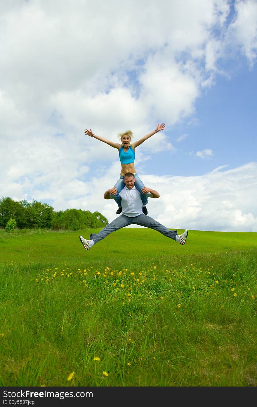 Young family jumping on a lawn