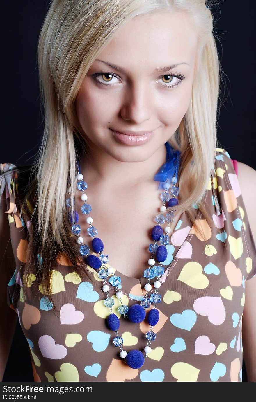 The beautiful girl in a sundress with a beads on a neck and a bracelet on a hand. The beautiful girl in a sundress with a beads on a neck and a bracelet on a hand