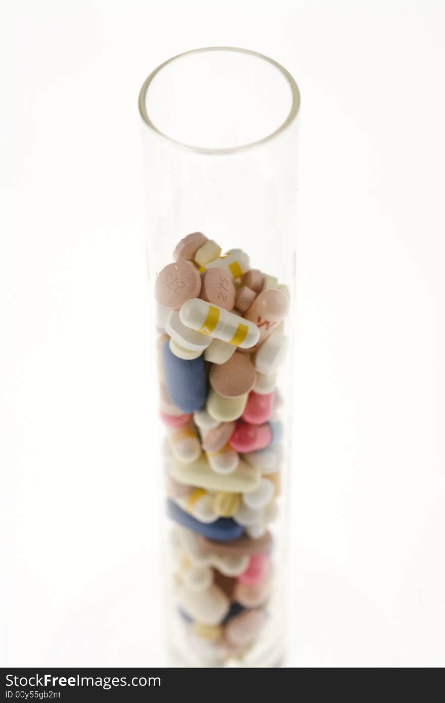 A jar filled with pills on white