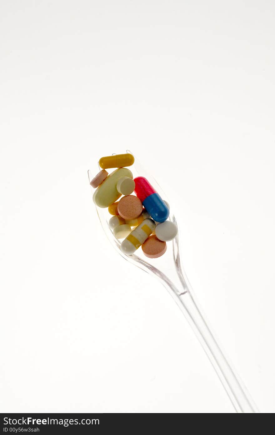 Fork with pills on a white background. Fork with pills on a white background