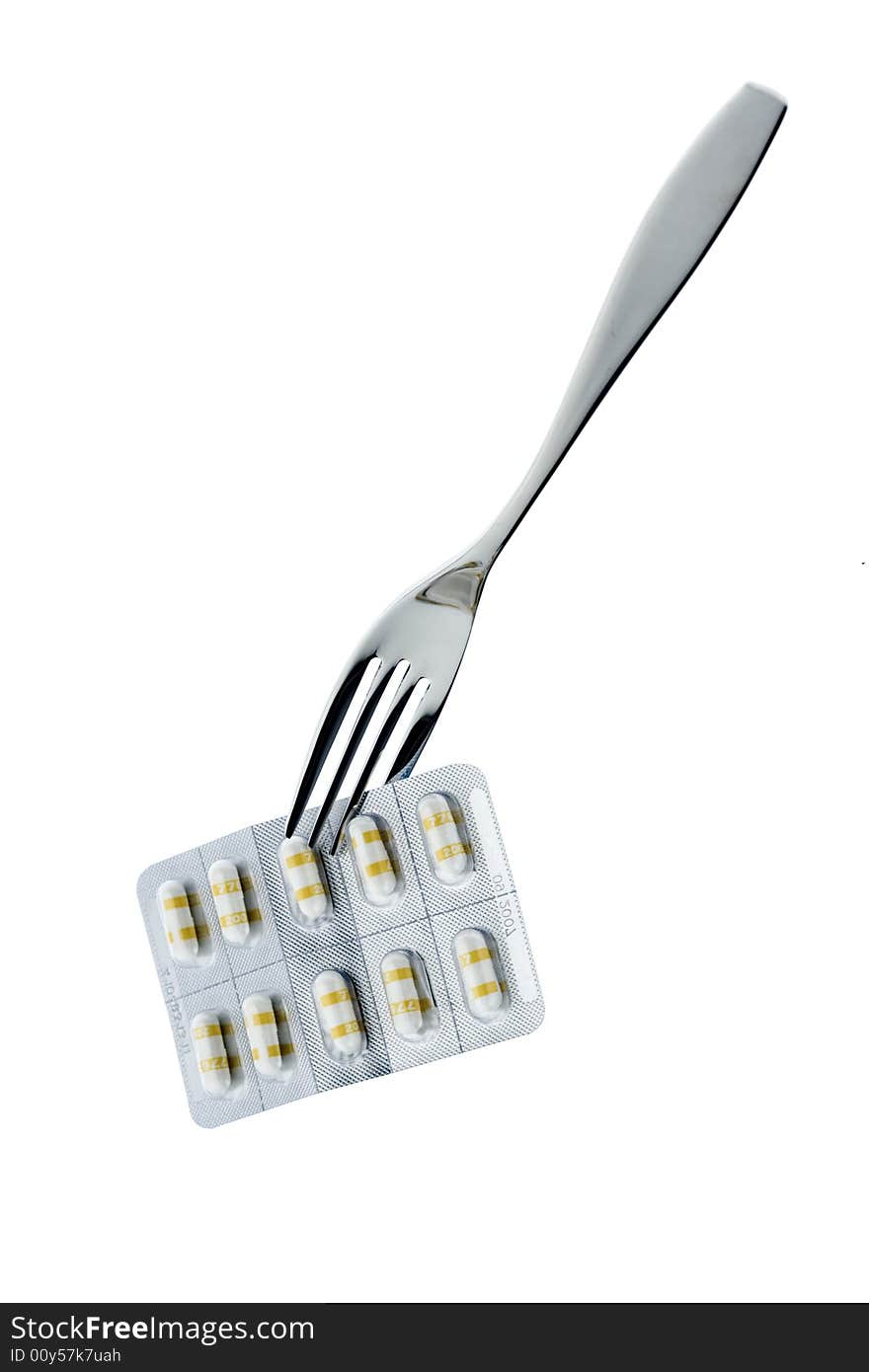 Fork with pills on a white background. Fork with pills on a white background