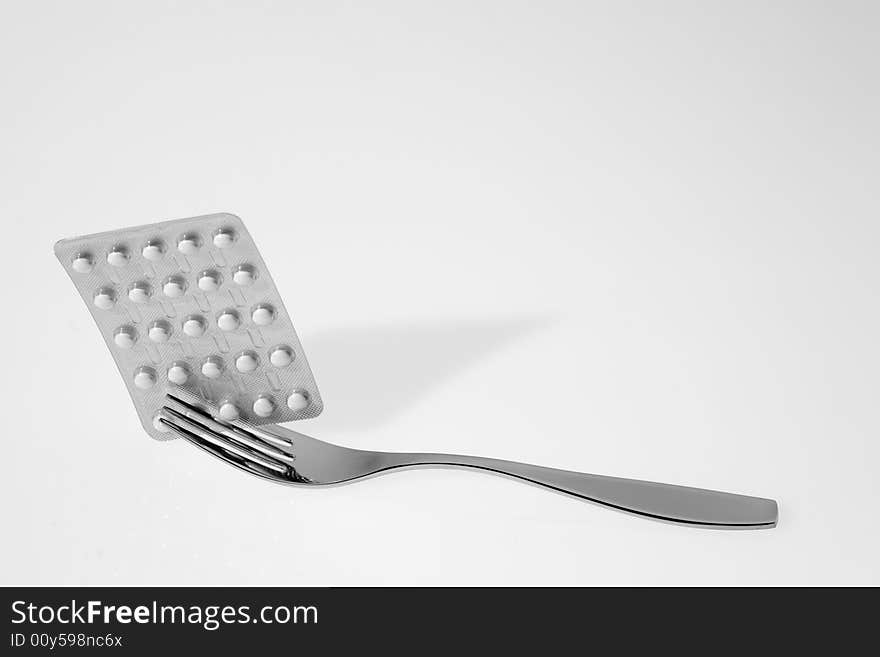 Fork with pills on a white background. Fork with pills on a white background