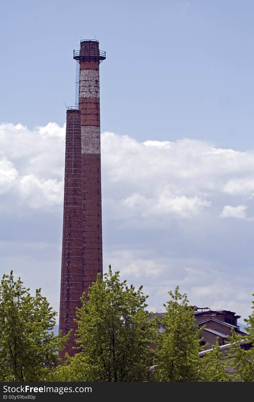 White and red chimney of factory against the sky and clouds. White and red chimney of factory against the sky and clouds.