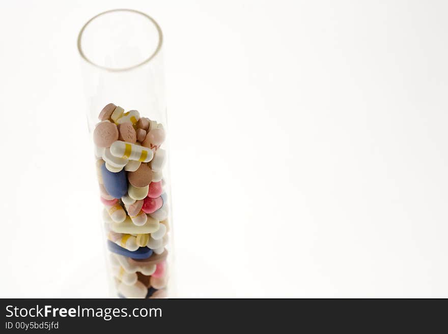 A jar filled with pills on white