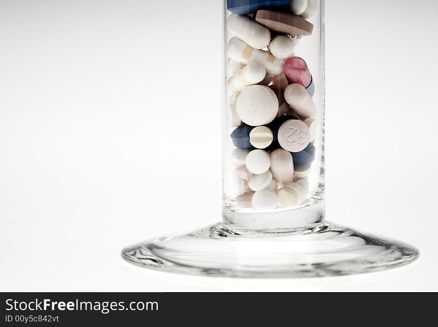 A jar filled with pills on white