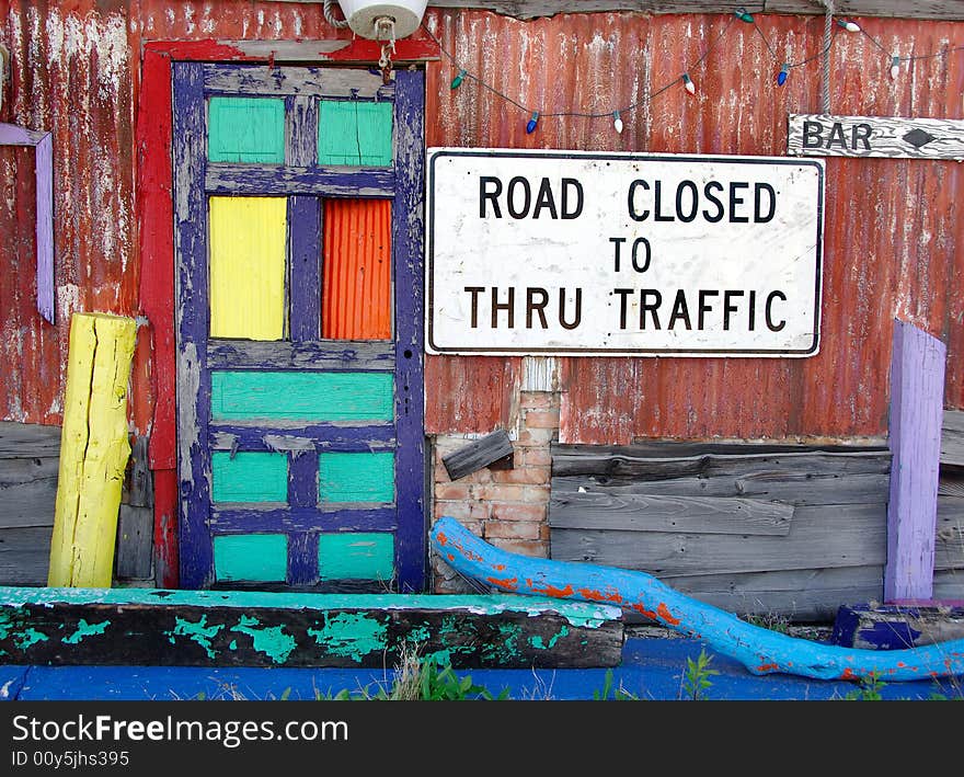 Abandoned structure painted in bright colors with an old road sign. Abandoned structure painted in bright colors with an old road sign.