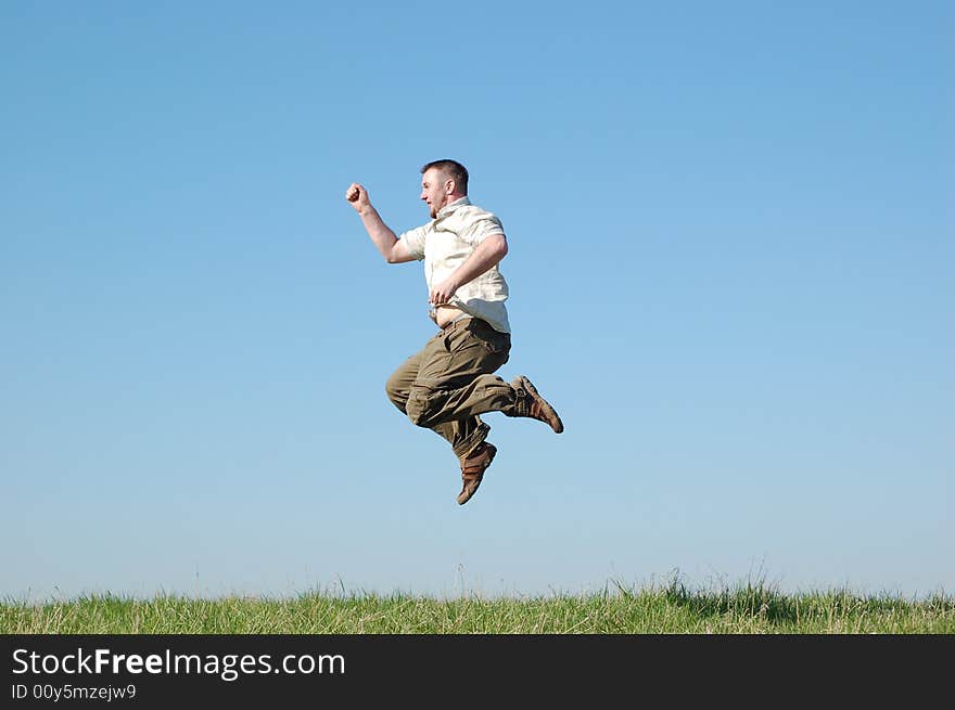 Happy man jumping on green meadow. Happy man jumping on green meadow