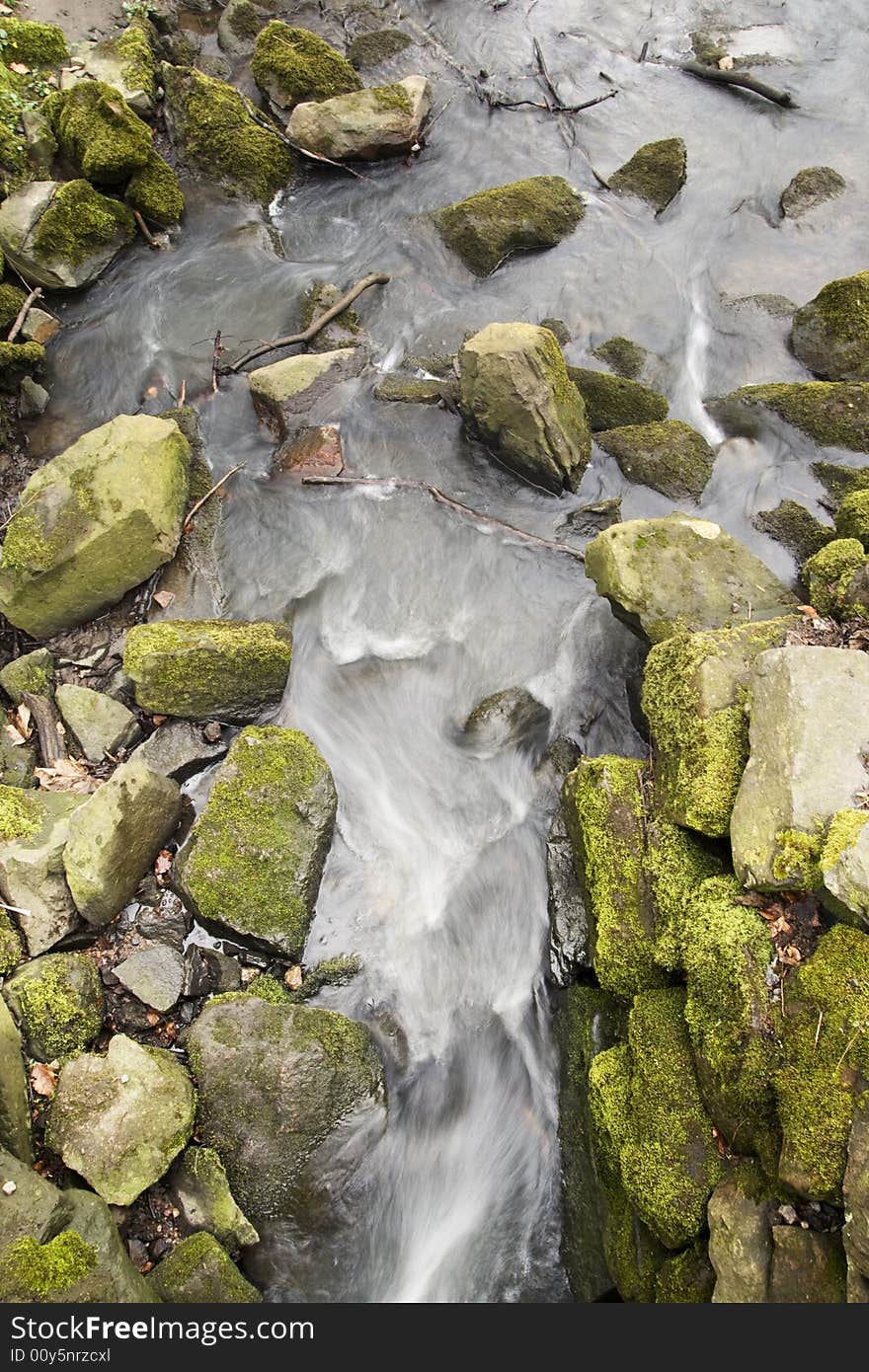 Abstract streaming grey water and mossy green rocks. Abstract streaming grey water and mossy green rocks.