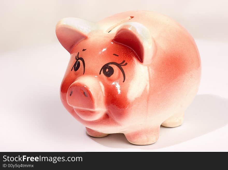 Pink ceramic piggy-bank isolated over white