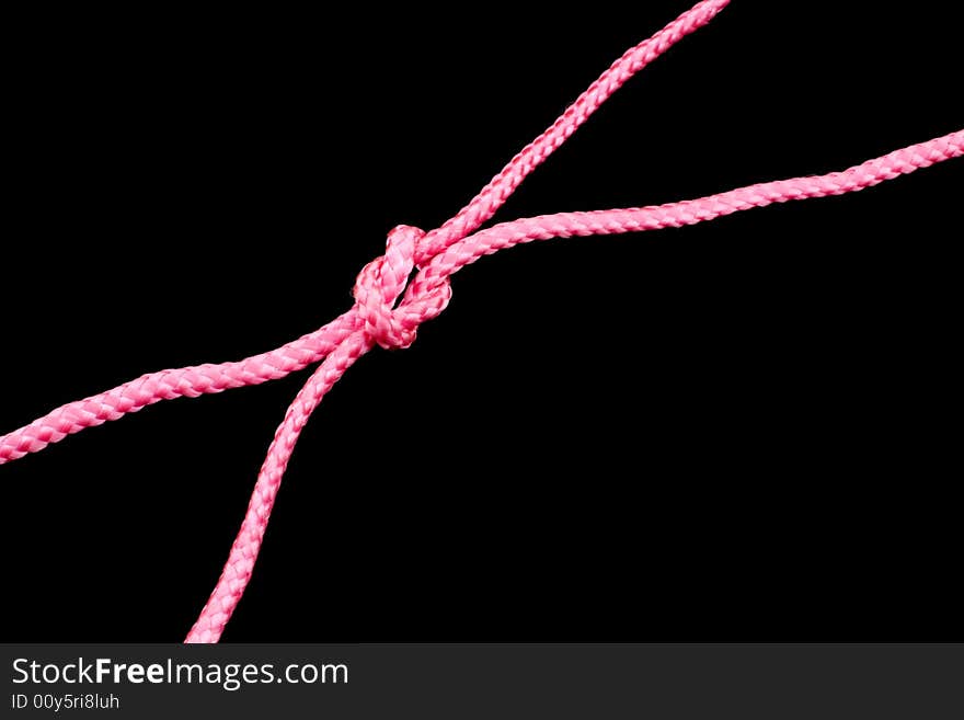 Pink ropes tied together, black background. Pink ropes tied together, black background