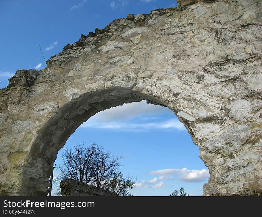 Arch of wall of an old building and  blue sky with clouds