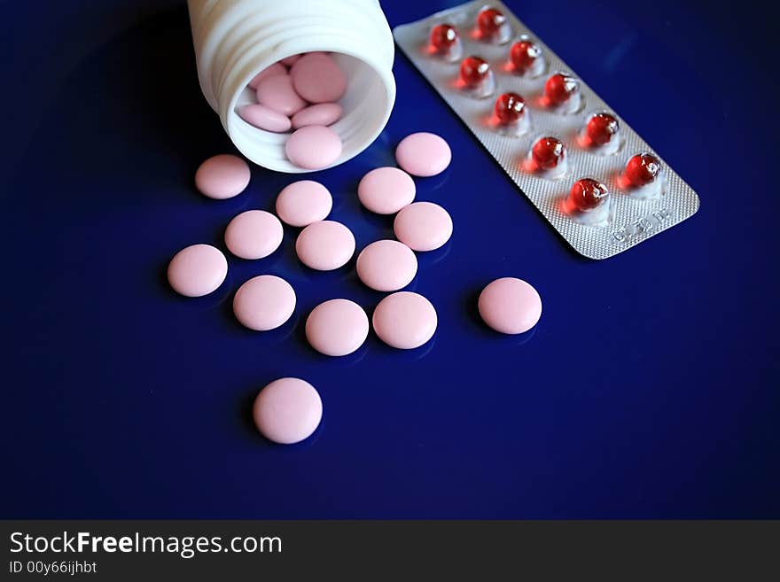 Tablets and pills on a dark blue background. Tablets and pills on a dark blue background.