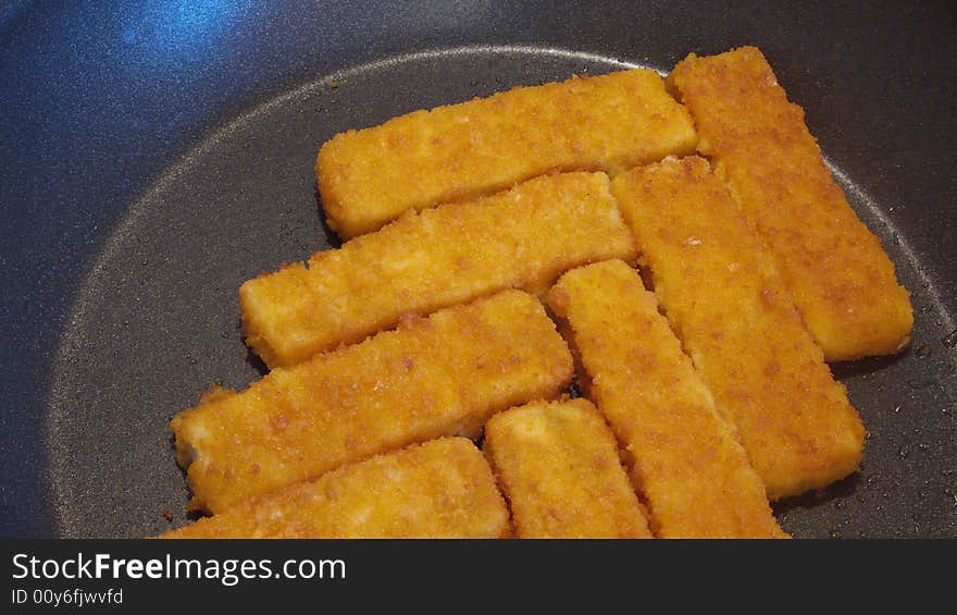 Rows of fish sticks in a pan