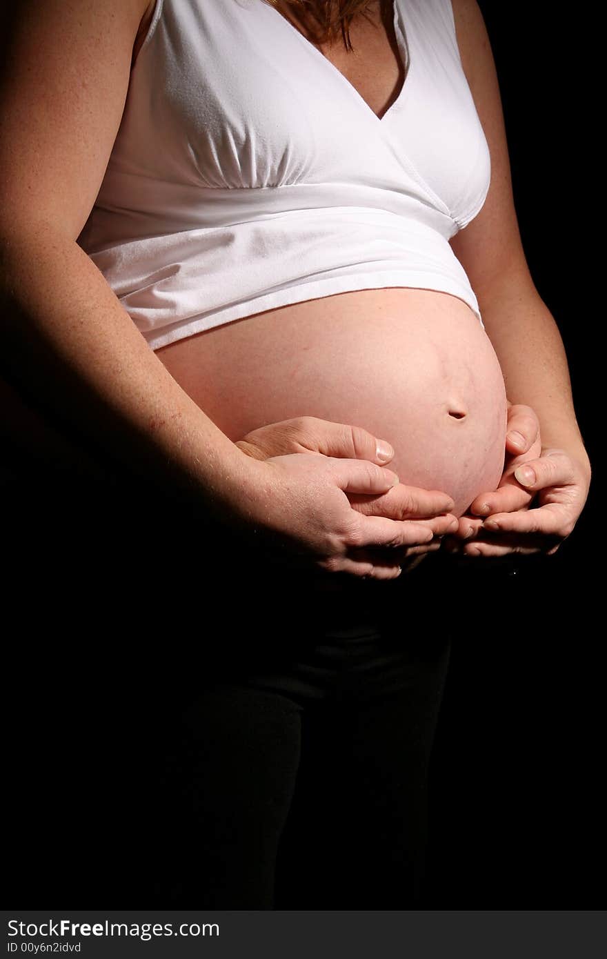 Father and Mother's hands Cradling Pregnant Belly. Father and Mother's hands Cradling Pregnant Belly