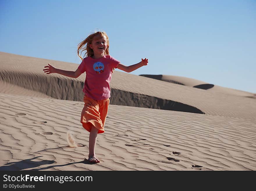 Young Girl Playing On Sand Dunes