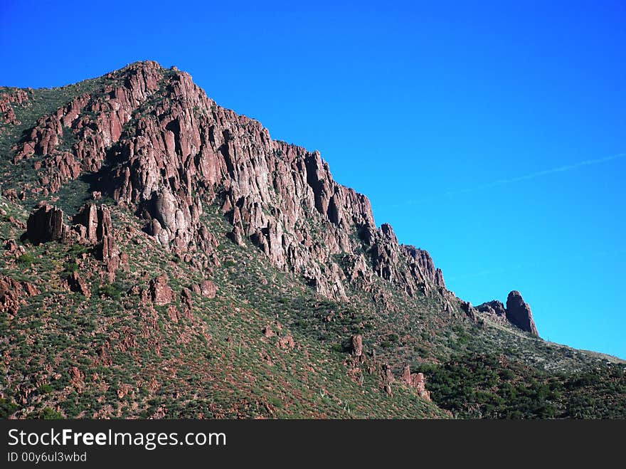 A majestic, reddish colored mountain jutting out of the desert floor near Superior, Arizona. A majestic, reddish colored mountain jutting out of the desert floor near Superior, Arizona