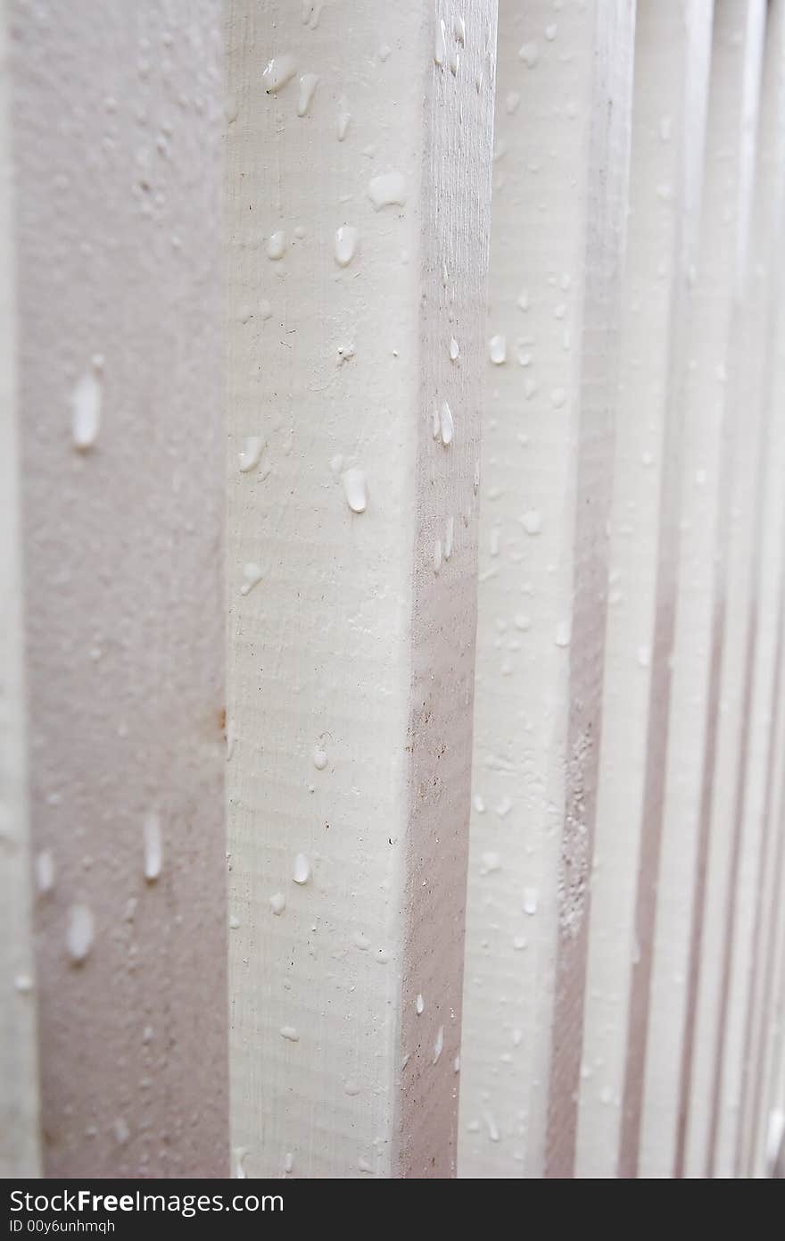 White painted wooden posts shown in profile with waterdrops. White painted wooden posts shown in profile with waterdrops