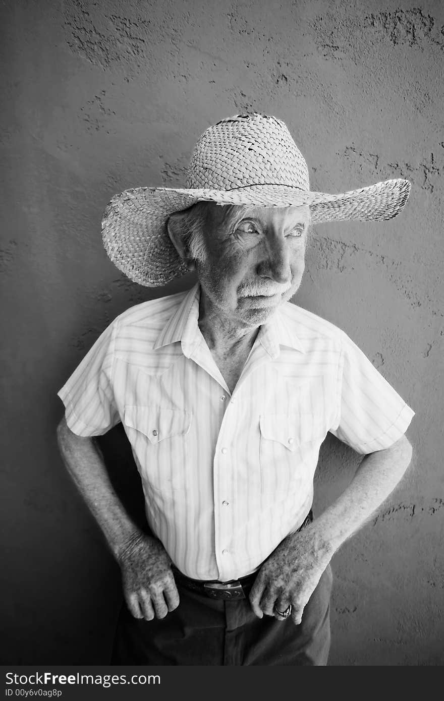 Senior Citizen Man Wearing a Straw Cowboy Hat Looks Off. Senior Citizen Man Wearing a Straw Cowboy Hat Looks Off