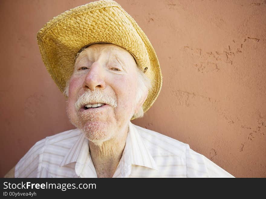 Senior Citizen Man with a Funny Expression Wearing a Straw Cowboy Hat. Senior Citizen Man with a Funny Expression Wearing a Straw Cowboy Hat