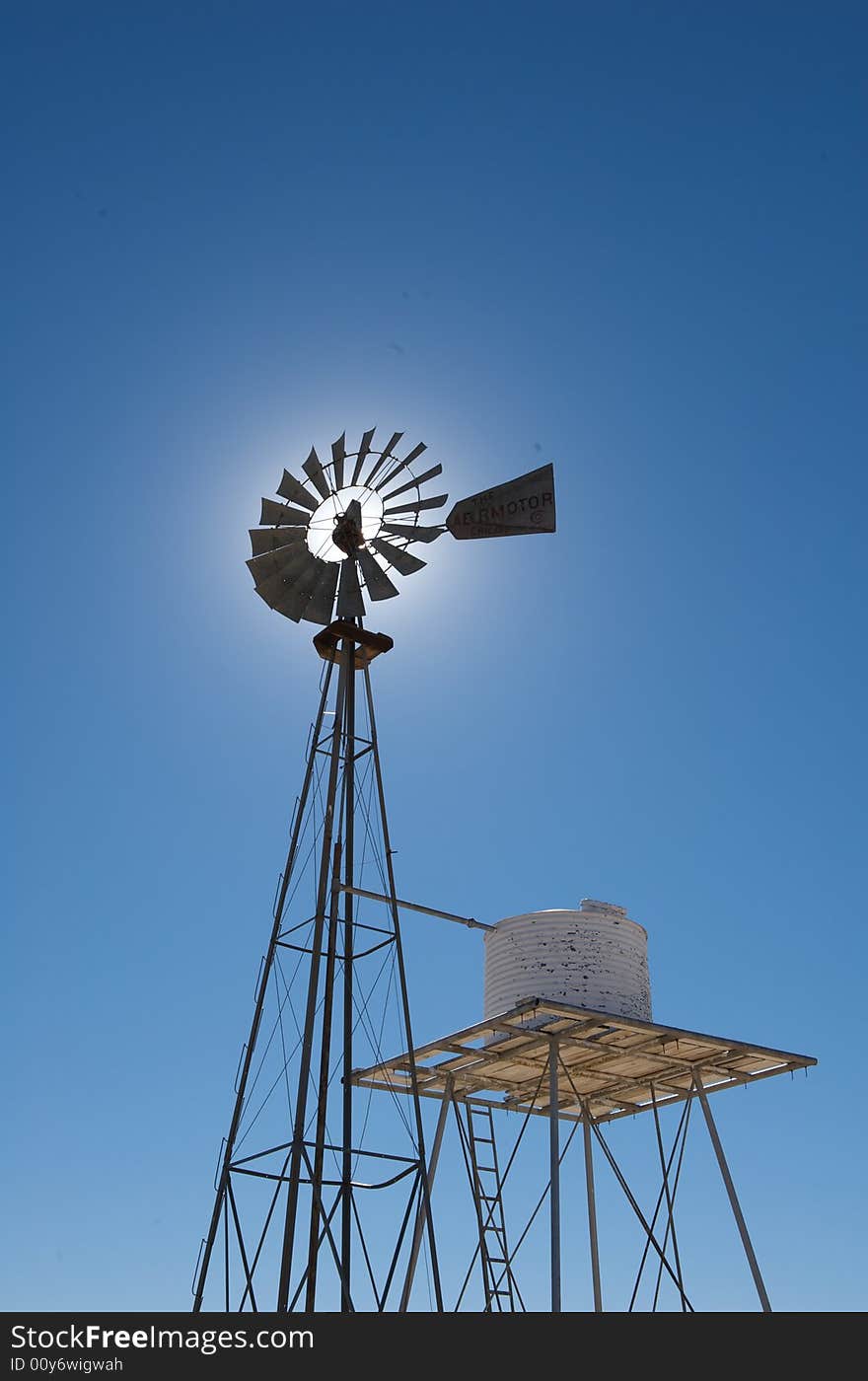 An image of a rustic windmill against a blue sky