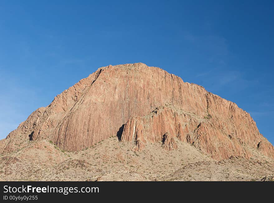 A Large Red Mountain On A Blue Sky