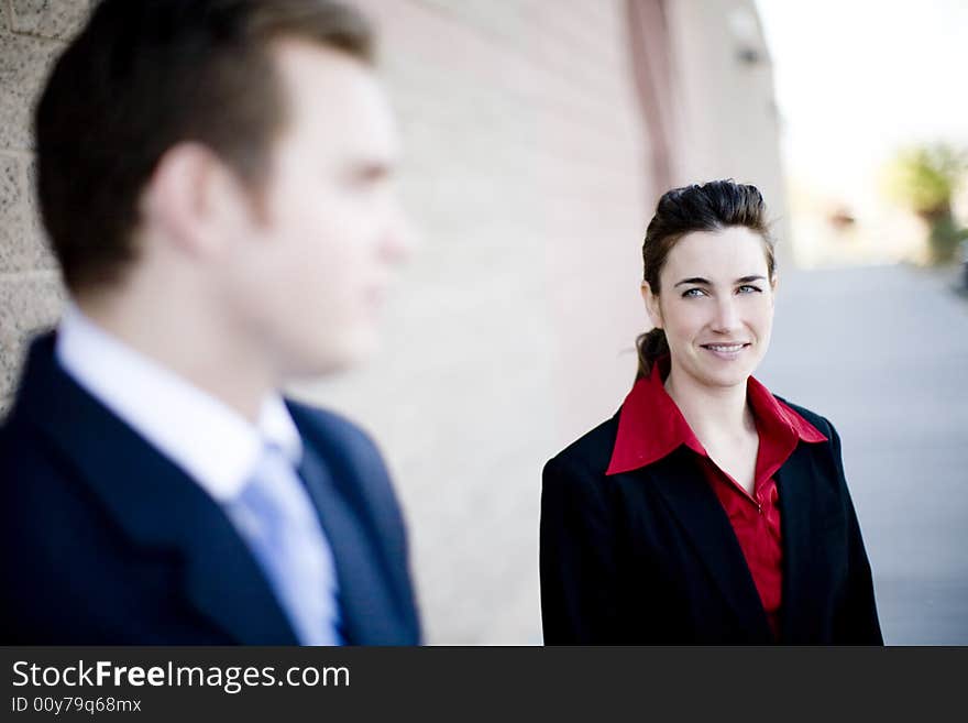 Attractive businesswoman and businessman standing looking at each other wearing formal business wear. Attractive businesswoman and businessman standing looking at each other wearing formal business wear