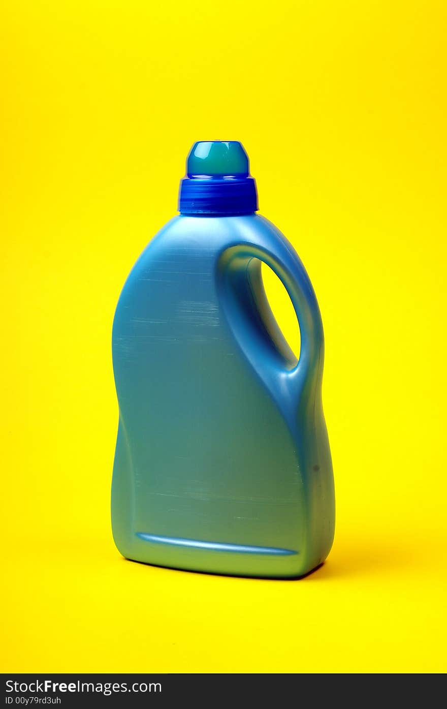 Cleaning supplies on yellow background including several spray bottles of chemicals