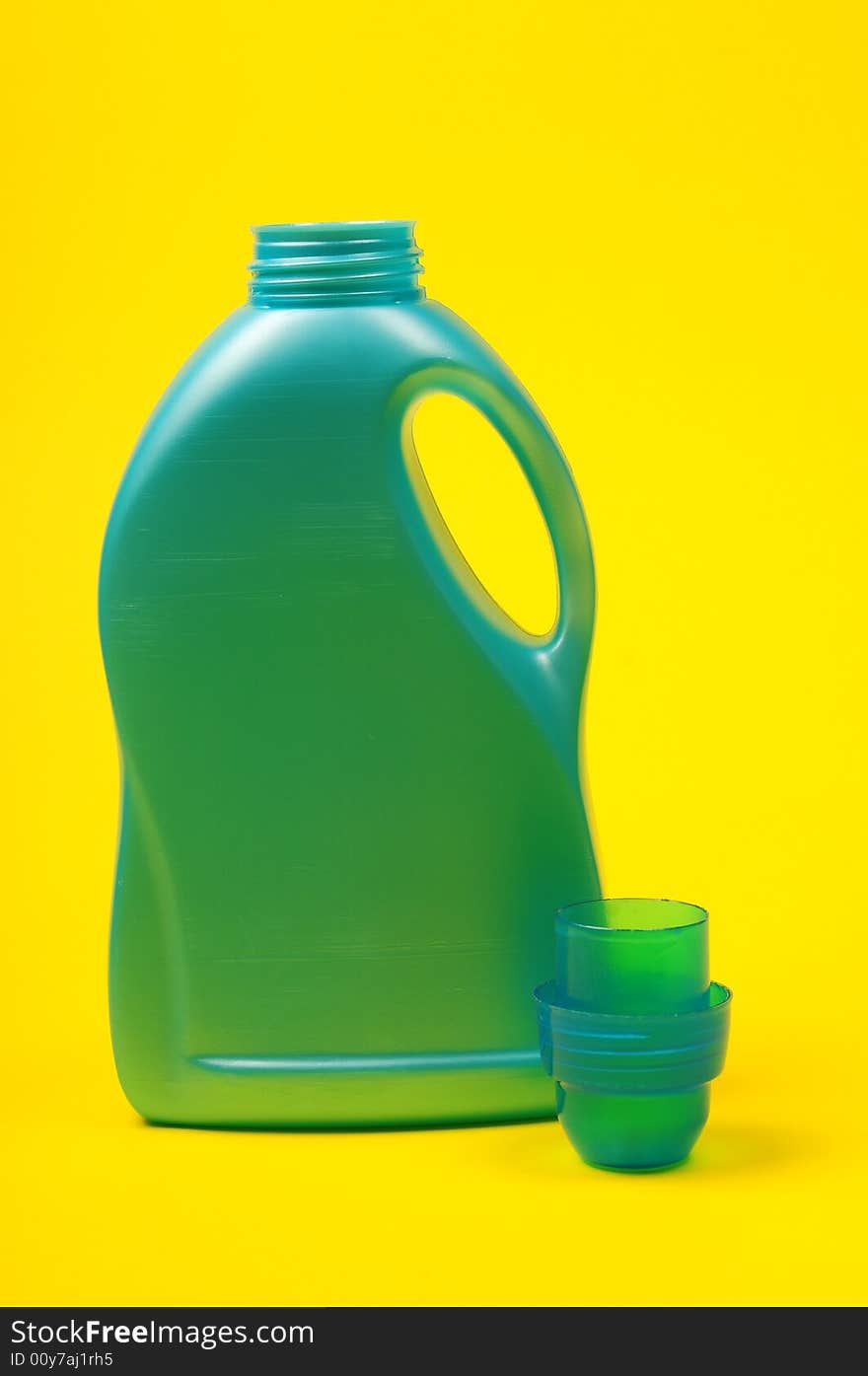 Cleaning supplies on yellow background including several spray bottles of chemicals