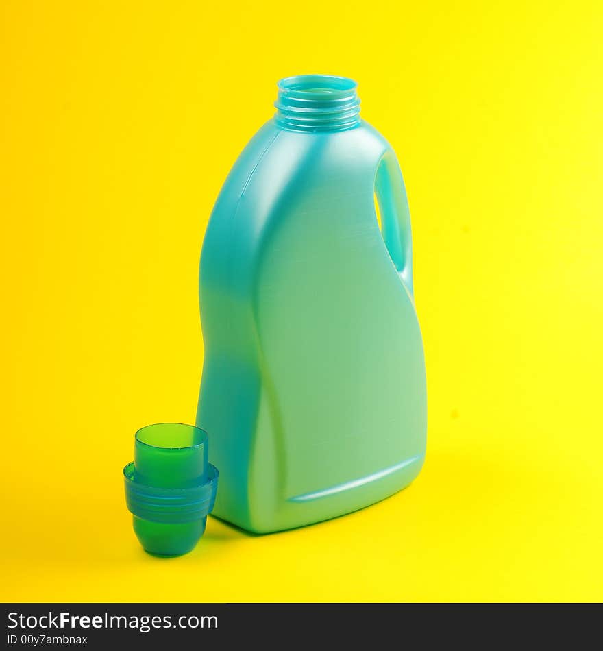 Cleaning supplies on yellow background including several spray bottles of chemicals