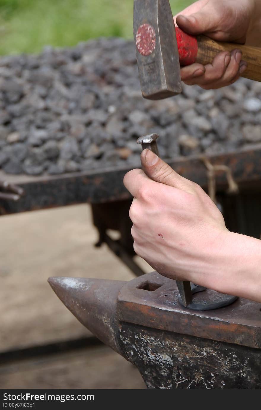 Keeping hammer and chip axe the blacksmith making horseshoe. Keeping hammer and chip axe the blacksmith making horseshoe