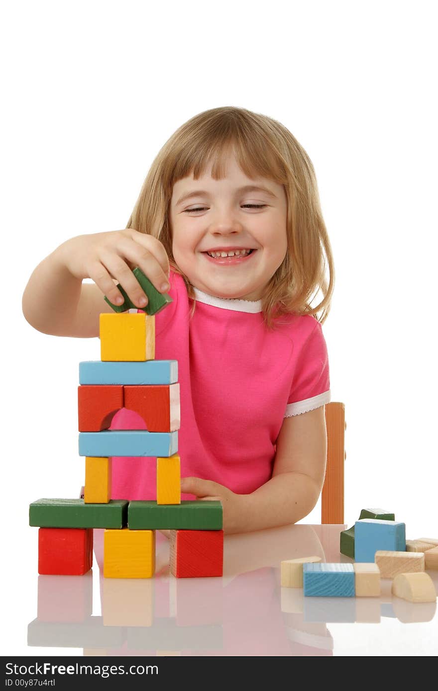 Little girl playing with cubes isolated on a white background