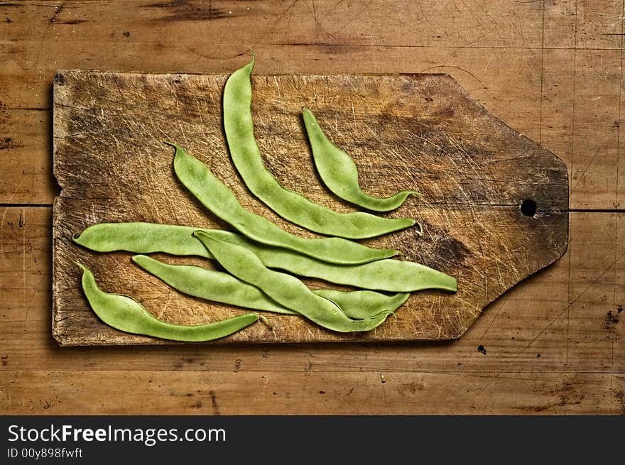 Green beans on wooden table.