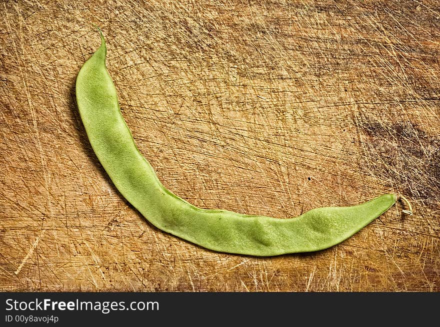 Green bean on wooden table.