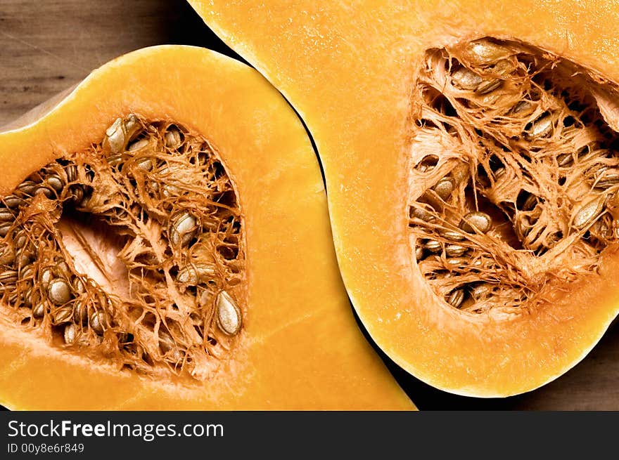 Pumpkin on wooden table halved. Studio shot. Pumpkin on wooden table halved. Studio shot.