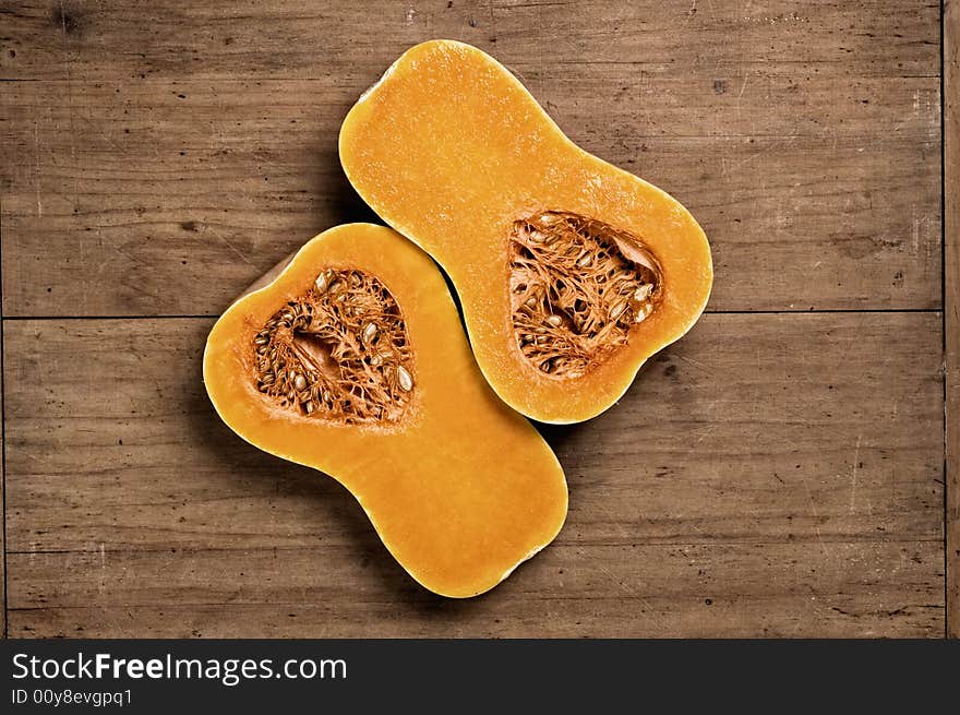 Pumpkin on wooden table halved. Studio shot. Pumpkin on wooden table halved. Studio shot.