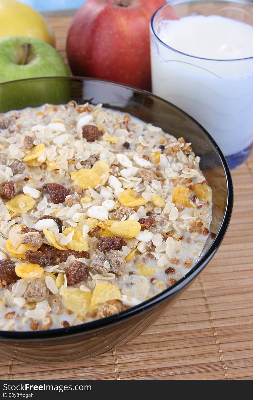 Corn flakes with milk and fruits on a deep plate