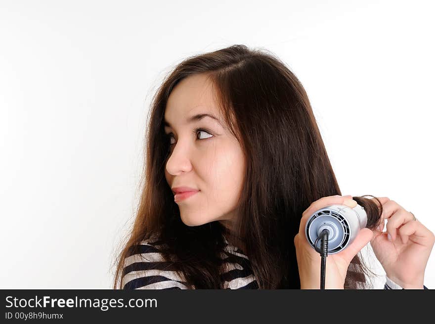 Beautiful brunette woman drying her hair with a dryer. Beautiful brunette woman drying her hair with a dryer