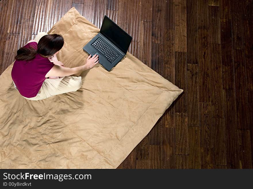 Woman sitting on the floor looking at a laptop screen. Horizontally framed shot. Woman sitting on the floor looking at a laptop screen. Horizontally framed shot.