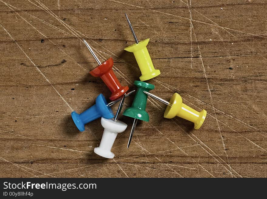 Push-pins of various colors on wood. Push-pins of various colors on wood.