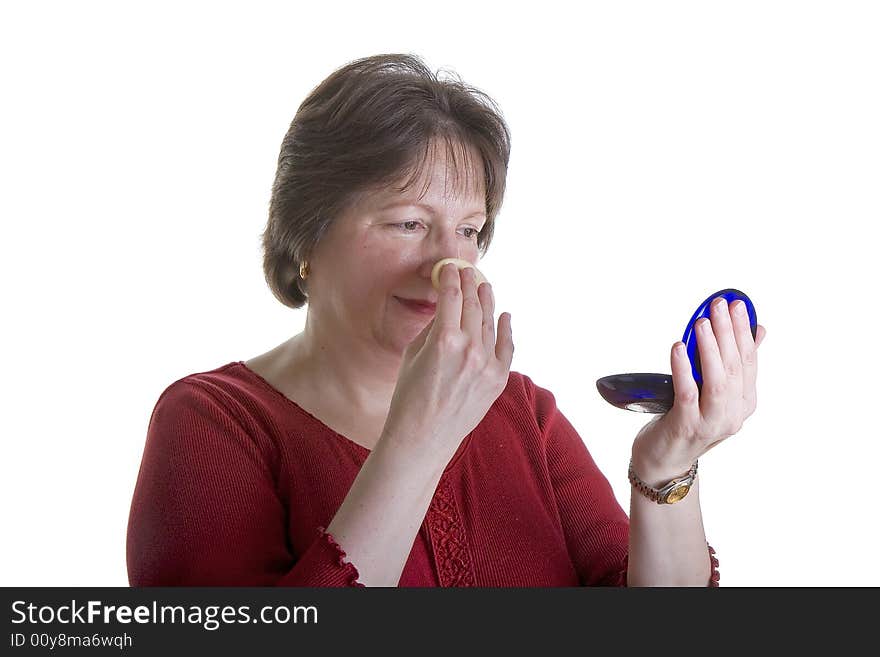 A woman in red on a white background powdering her nose. A woman in red on a white background powdering her nose