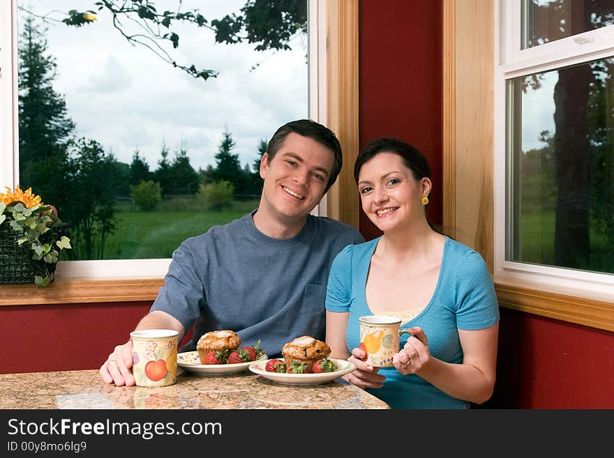 A Smiling Couple Eating Breakfast At Home