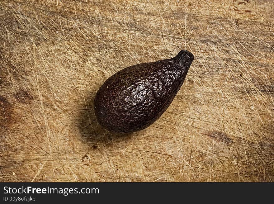 Avocado on wooden table, studio shot. Avocado on wooden table, studio shot.