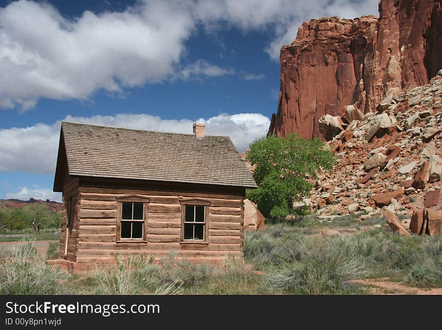 Historic one room log school house in Capitol Reef National Park. Geologic features in background. Utah. USA. Historic one room log school house in Capitol Reef National Park. Geologic features in background. Utah. USA