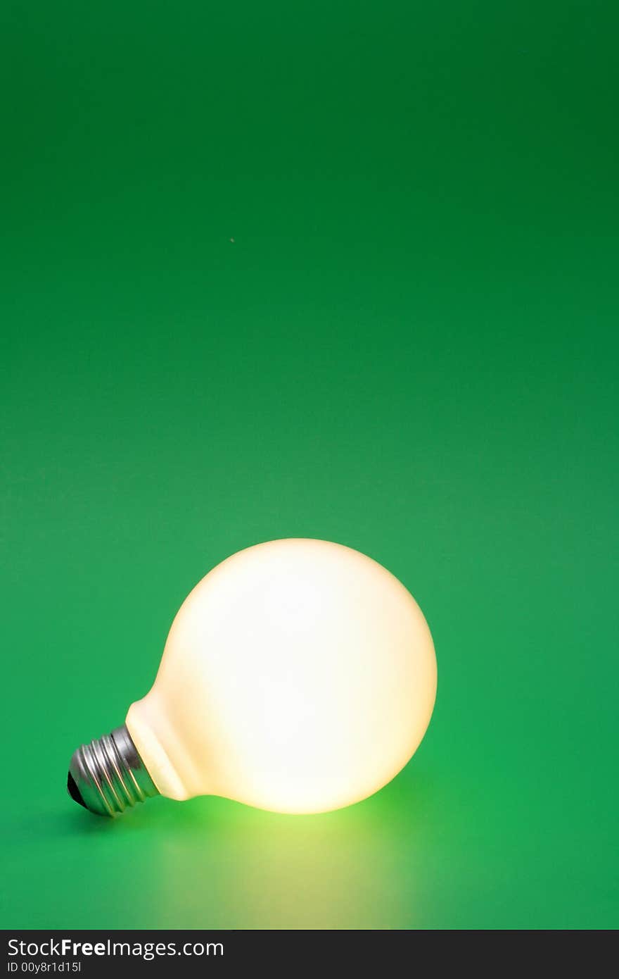 A lit up light bulb on a green background.