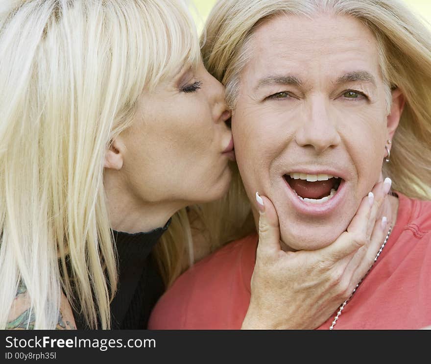 Outdoor portrait of a woman kissing a man