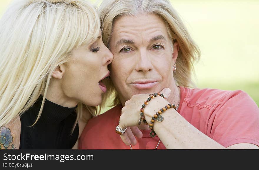 Outdoor portrait of a woman kissing a man