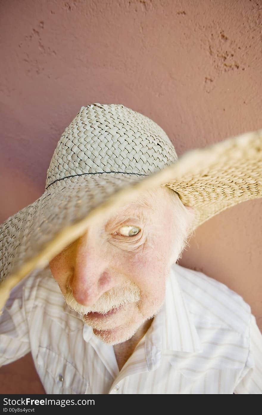 Senior Citizen Man with a Funny Expression Wearing a Straw Cowboy Hat. Senior Citizen Man with a Funny Expression Wearing a Straw Cowboy Hat